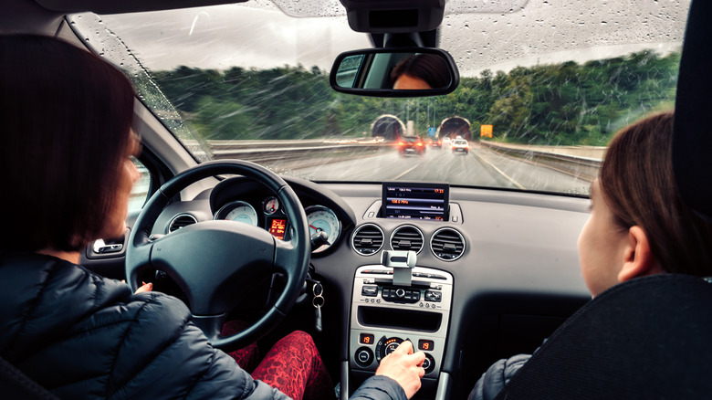 driver and passenger riding in rain