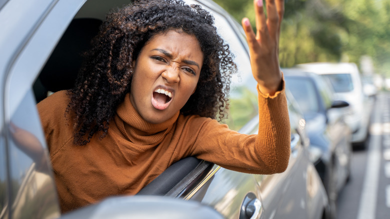 woman gesturing angrily out car window