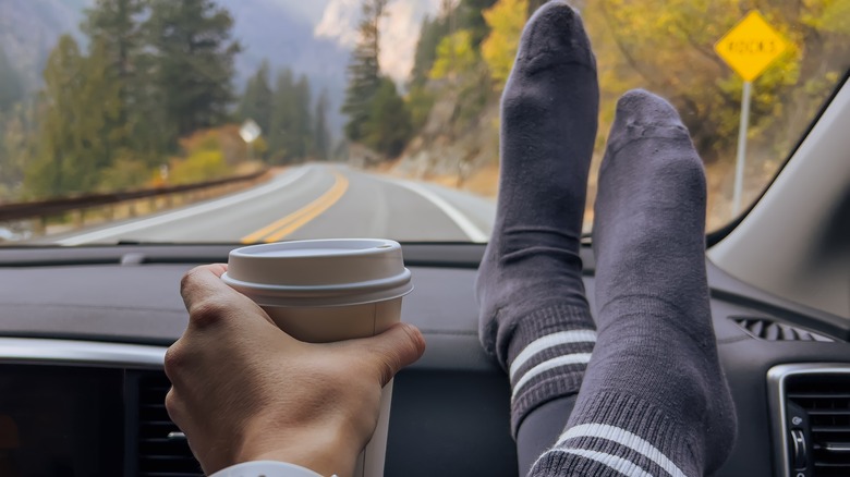 feet on dash of car on mountain road