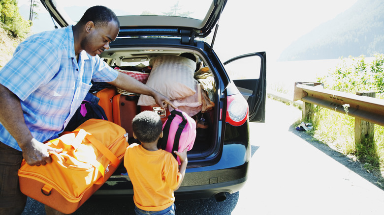 Father packing a car with child