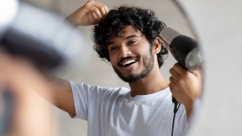 man blowdrying his hair