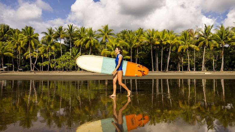 Surfer walking along Costa Rica beach