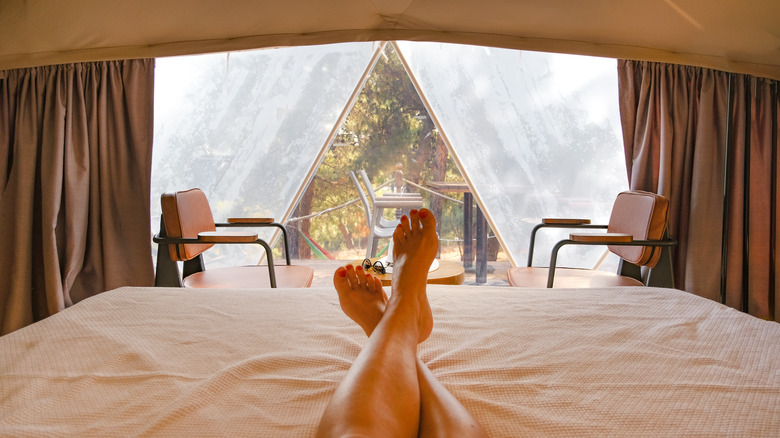 Person's legs inside glamping tent