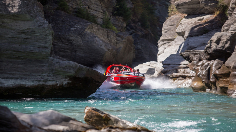 Tourists enjoy a high speed jet boat ride on the Shotover River Queenstown, New Zealand.