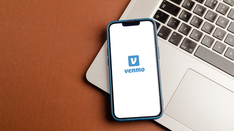 mobile phone showing Venmo logo sitting on laptop keyboard