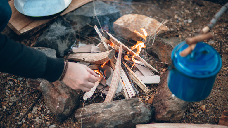 Person lighting a campfire