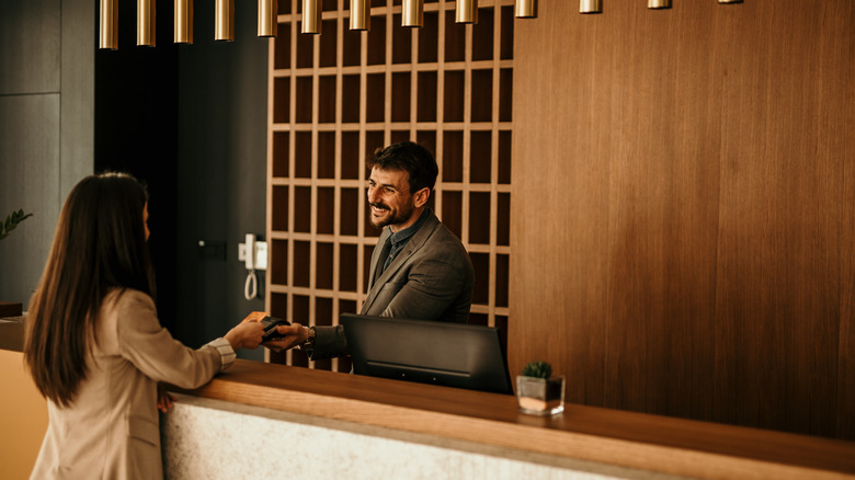 Traveler speaking to hotel concierge at desk