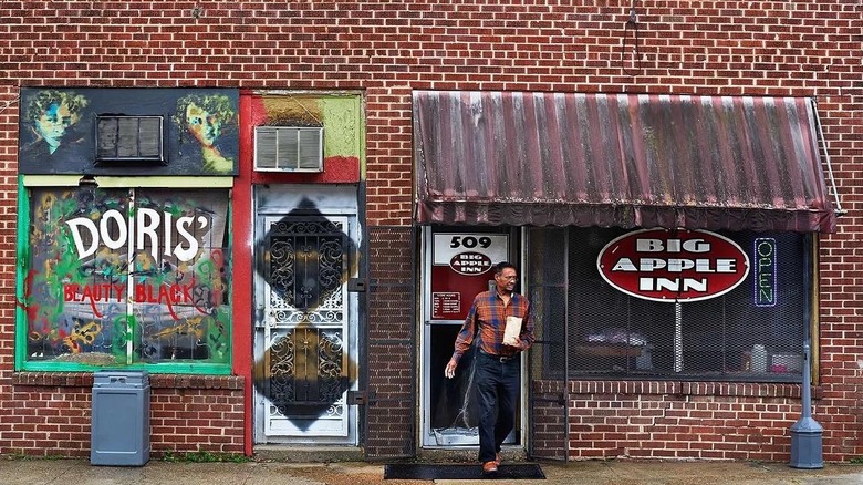 Man leaving small restaurant in brick building