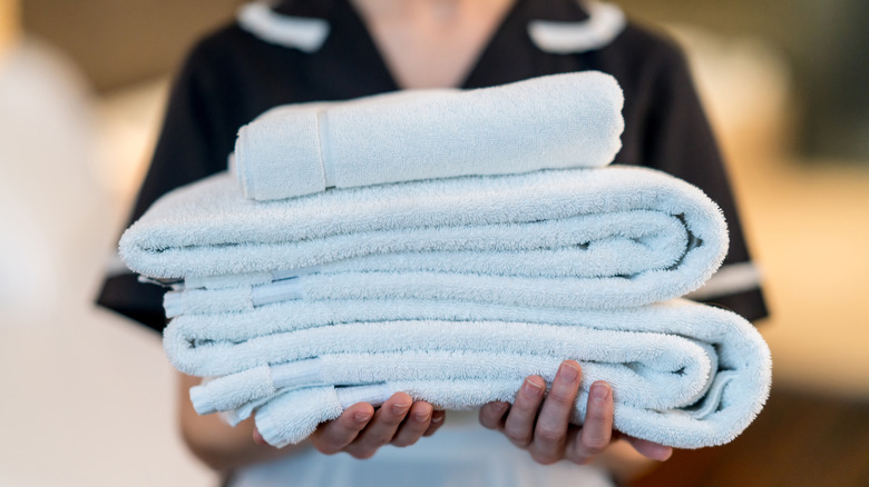 hotel housekeeper holding towels