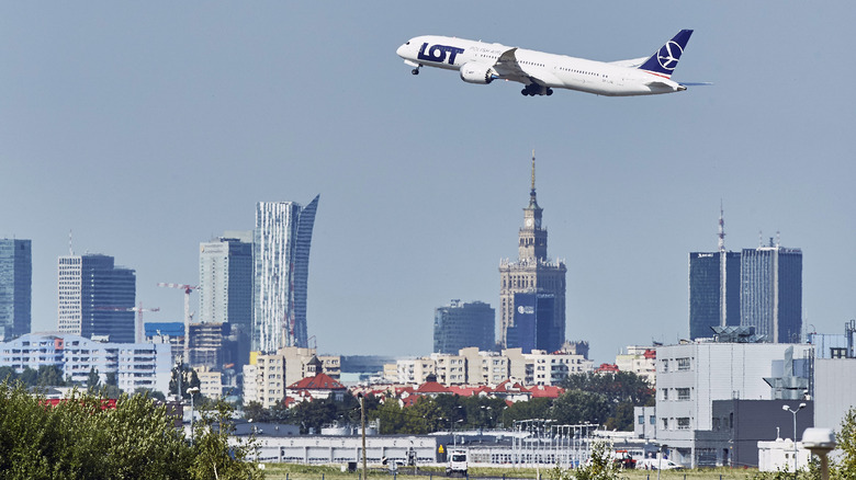 plane flying by Warsaw skyline