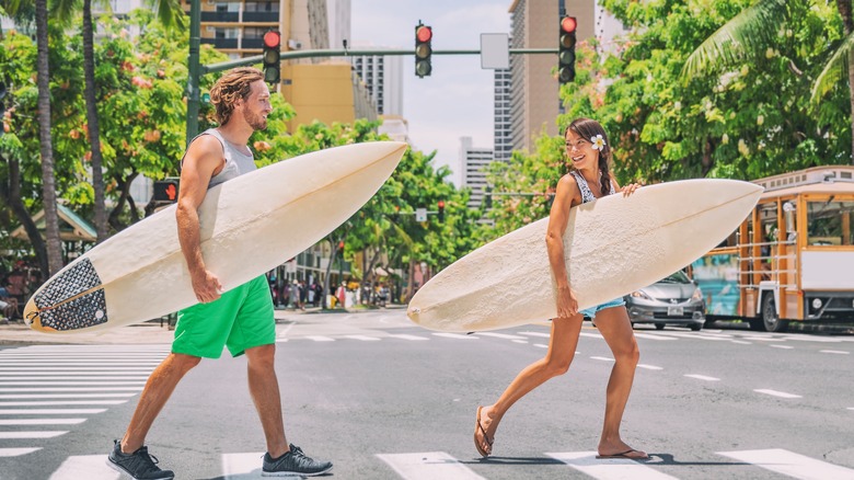 Couple holding surfboards at Waikiki Beach