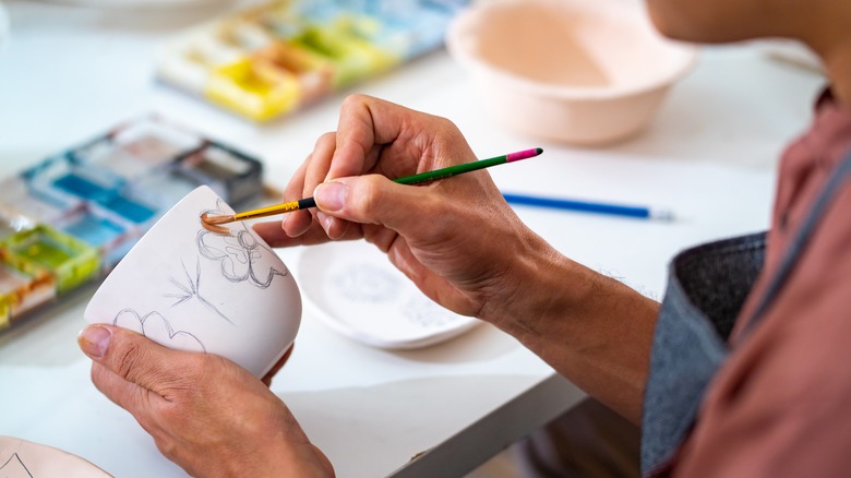 A man paints pottery