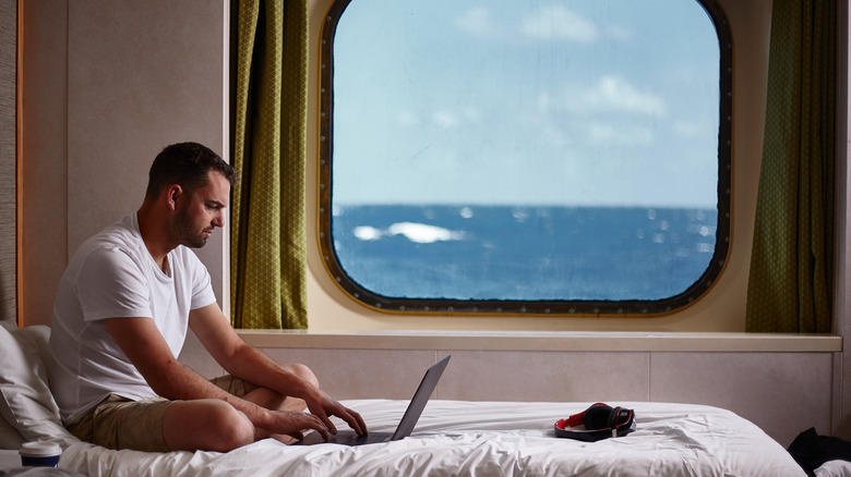 Man on cruise ship by window