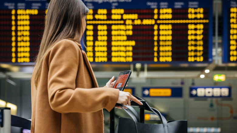 Traveler standing by flight information board