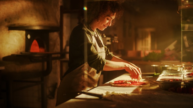 Woman making pizza in a restaurant