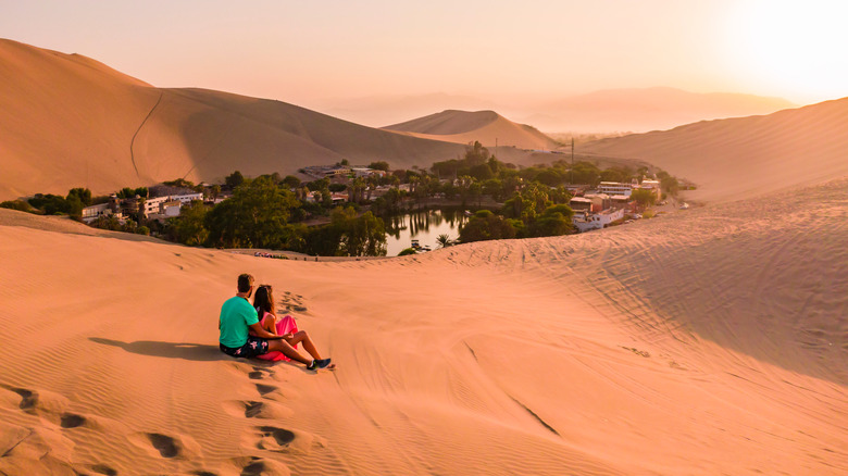 Couple sitting on Huacachina dunes