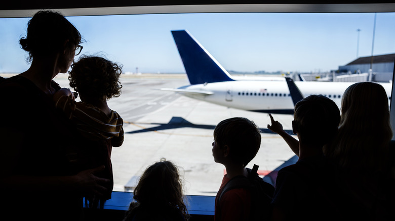 Family looking at airplane on runway