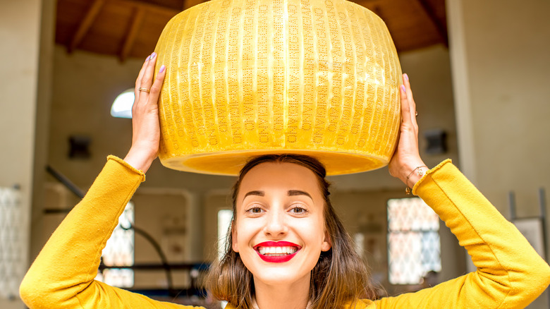 Woman holding a wheel of cheese
