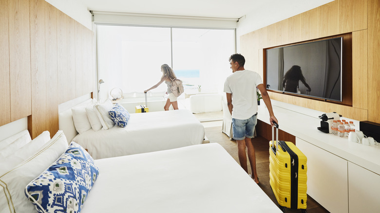 A couple enters a clean hotel room.