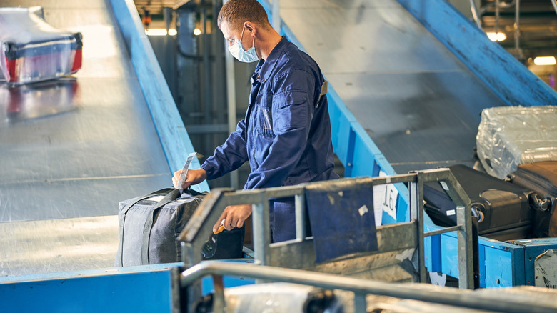 Luggage handler checking suitcase