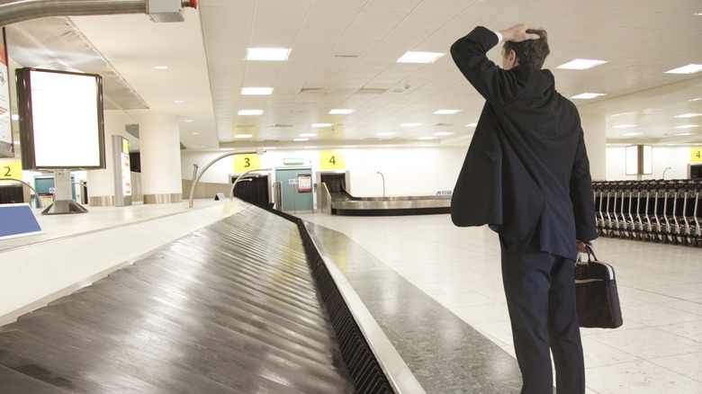 man at empty baggage carousel