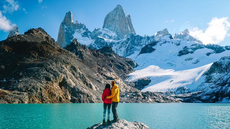 Two people by lake and mountain