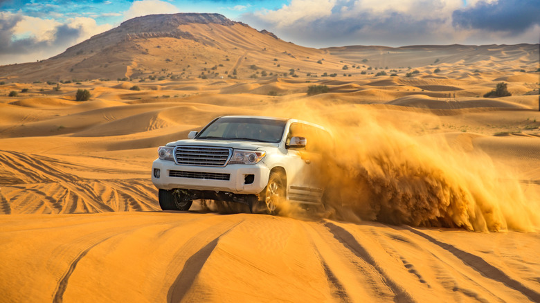 car driving through desert sand