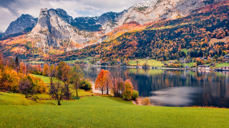 Calm autumn view of Grundlsee lake with huge mountain range on background.