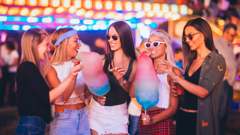 friends eating cotton candy at festival