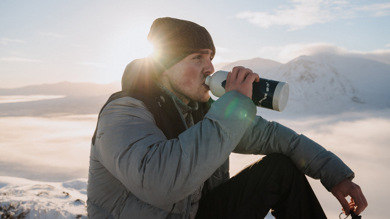 Man drinks water on mountain
