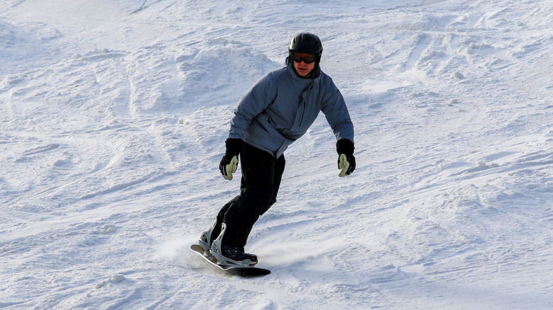 A man rides a snowboard down a Vermont slope