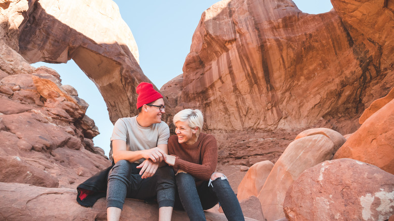 couple sitting on red rocks