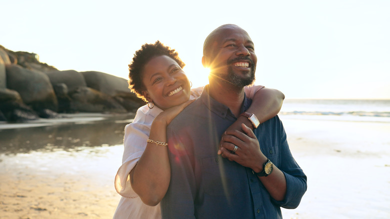 Smiling couple hugging on beach