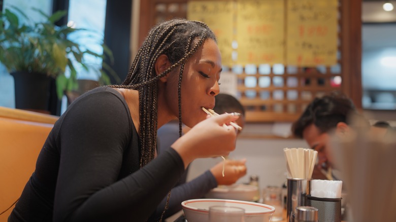woman eating ramen in restaurant