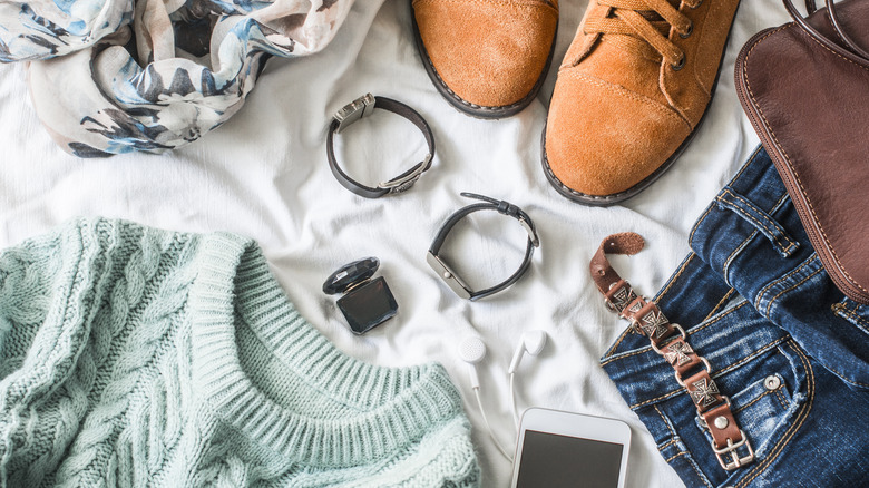 clothing laid out on the bed before a trip