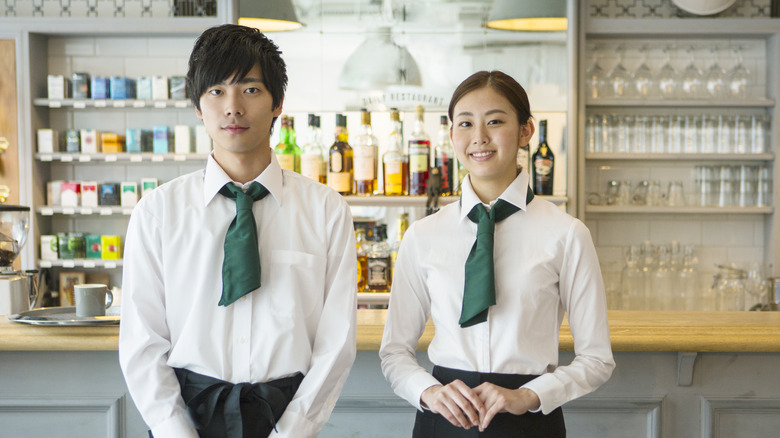 Two Japanese restaurant servers posing barside