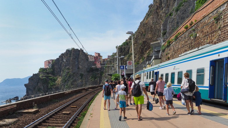 People board a train in Cinque Terre