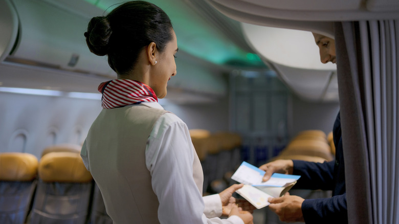 flight attendant helping passenger