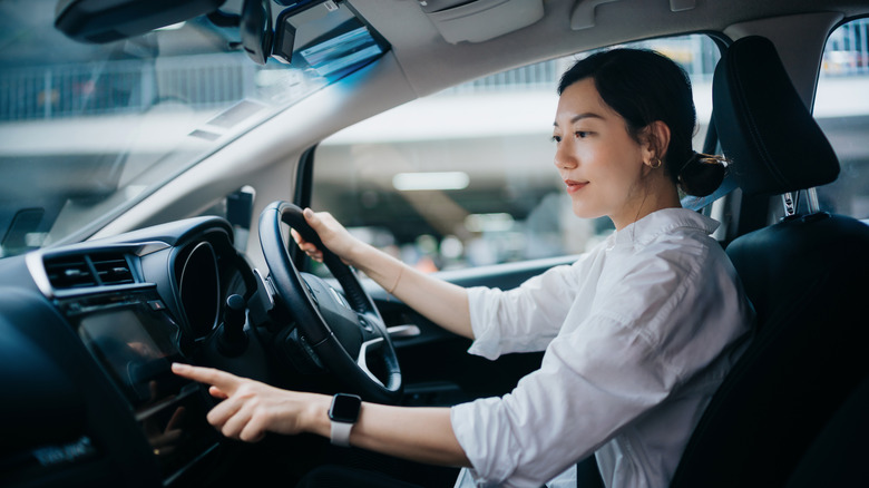 Woman touching screen in car