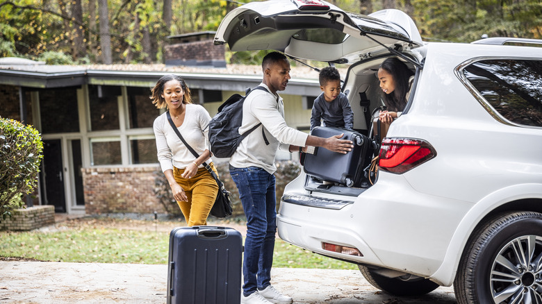 Family placing suitcases in car