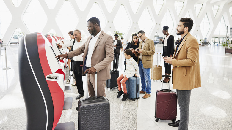 travelers at airport check-in kiosk