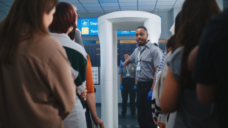 TSA officer with passengers waiting to go through screening