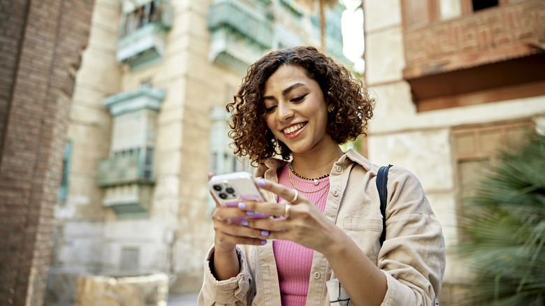 smiling person looking at phone