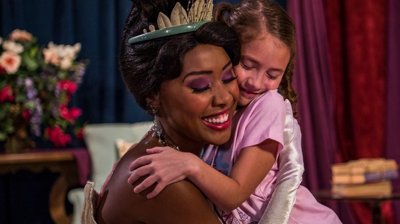 Disney princess Tiana hugging visitor