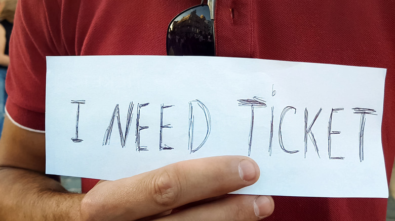 Man with I need ticket sign