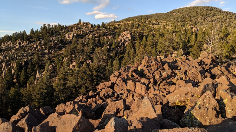 A boulder field amid rolling green mountains