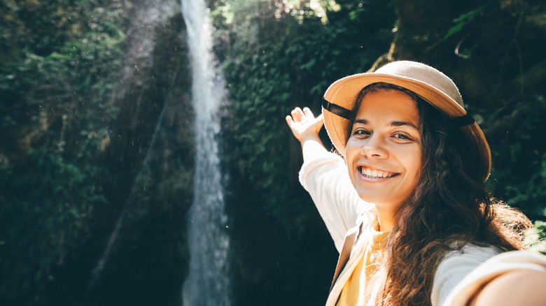 woman taking selfie with waterfall