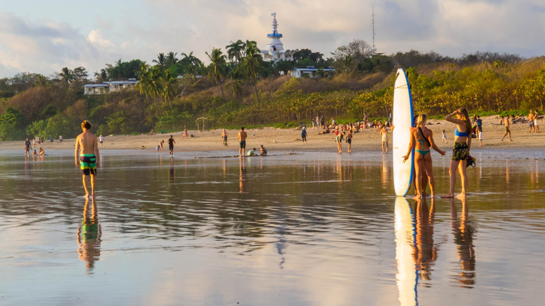 Surfers and beach goers at the shore in Nosara