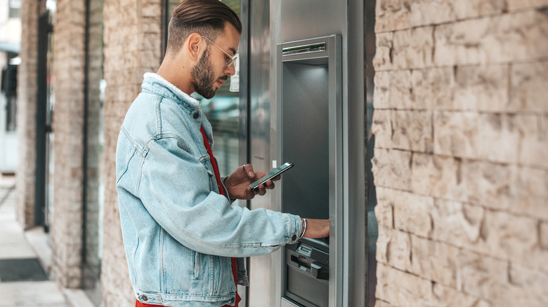 Traveler withdrawing cash from ATM