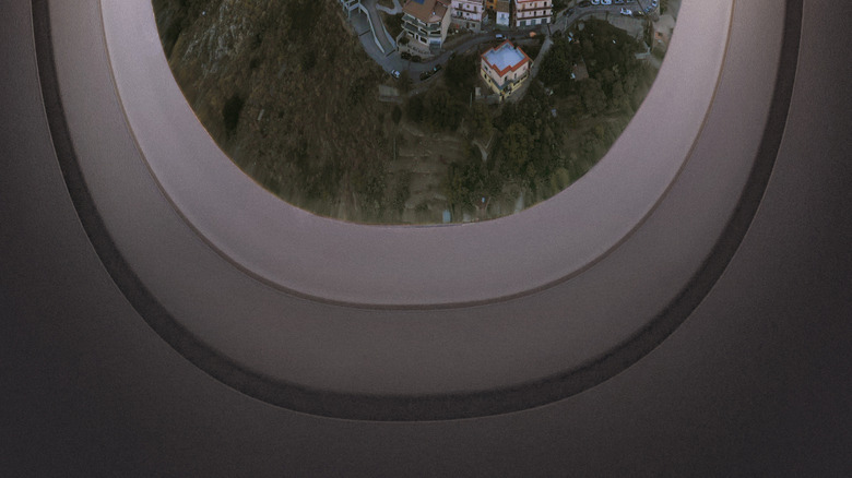 Plane window view of an Italian village and coastline